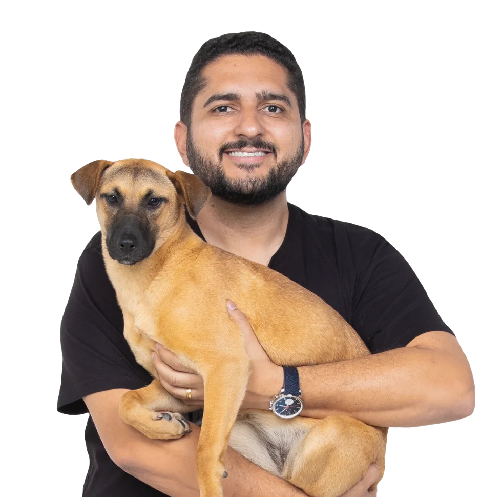 Thiago Ganem segurando no colo um cachorro caramelo resgatado.